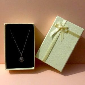 Small silver pine cone necklace.
